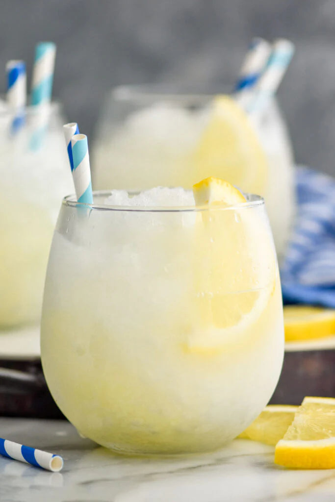 Frozen limoncello mule slush cocktail in glass with ginger beer and lemon garnish