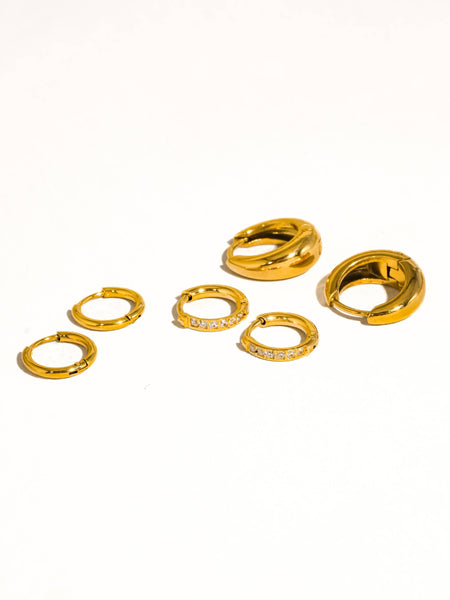 Set of gold hoop earrings on a white background