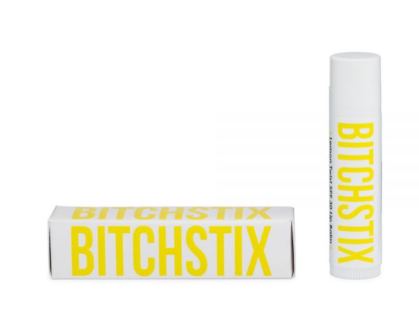 A stick of Pineapple Twist SPF 30 Lip Balm with its packaging, the packaging has bold yellow lettering on a white background.