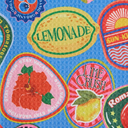 Colorful fabric with lemonade, lime crush, and tomatoe labels on a blue background