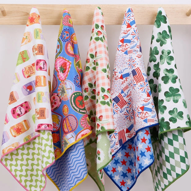 Set of colorful patterned towels hanging on a wooden rack.