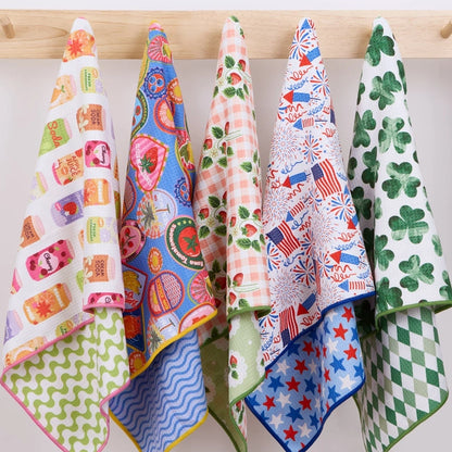Set of colorful patterned towels hanging on a wooden rack.