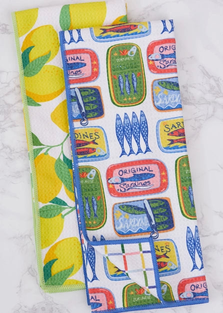 Two kitchen towels, one with lemons and the other with fish and label designs, on a white background.