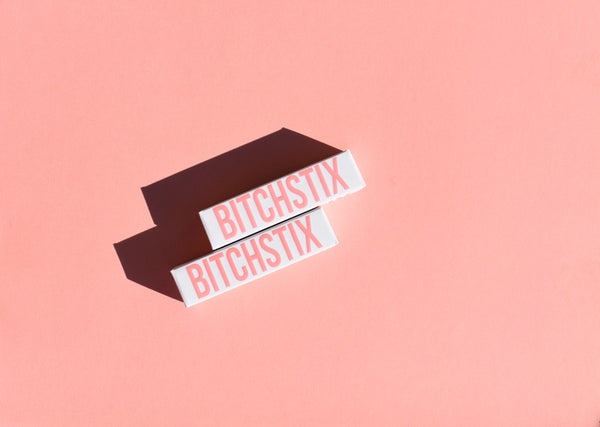 Two 'Bitchstix' products on a pink background