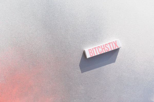 Small rectangular object with 'BITCHSTIX' text on a textured surface