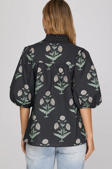 Woman wearing navy botanical floral print smocked V-neck top with puff sleeves and jeans
