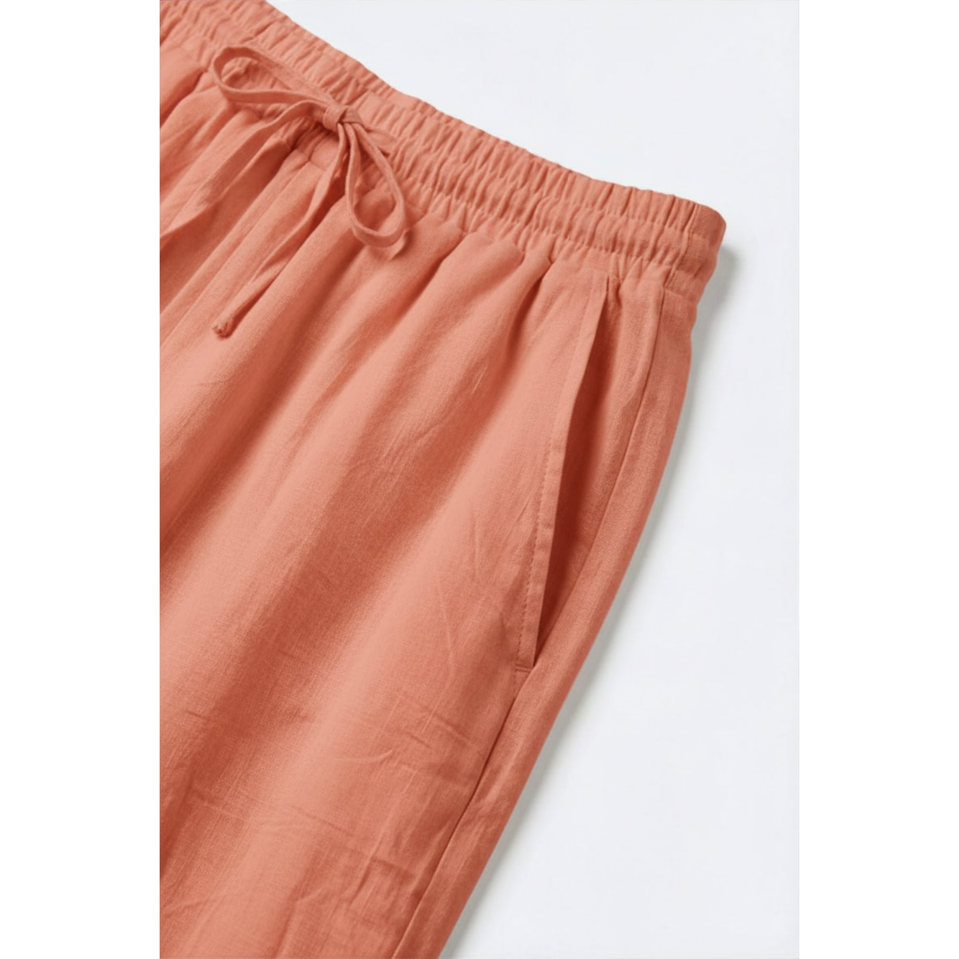 Coral-colored pants with an elastic waistband on a white background
