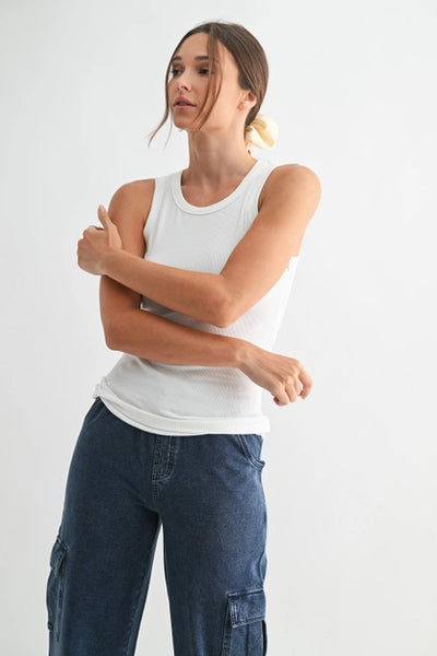 White ribbed tank top styled with blue cargo pants.
